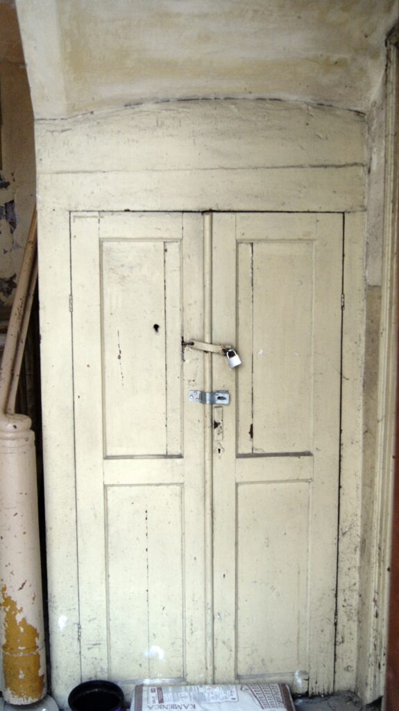 Drzwi do piwnicy na klatce schodowej skrzydła od strony ulicy Wilczej. Fot. Monika Wesołowska, 2020, źródło: lapidarium detalu.