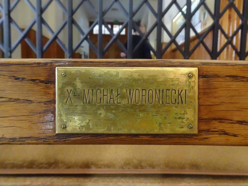 Tabliczka na ławce w kaplicy pw. Matki Bożej Nieustającej Pomocy. Fot. Katarzyna Komar-Michalczyk, 2020, źródło: lapidarium detalu.