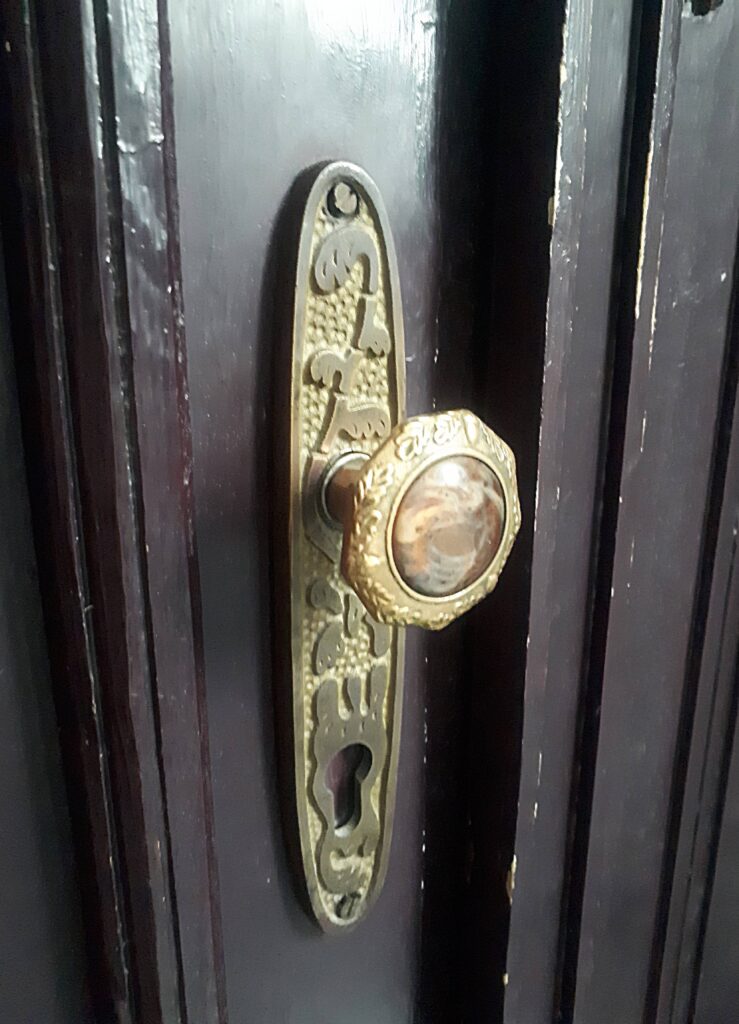 Klamka u drzwi do mieszkania, klatka schodowa w oficynie płn. Fot. Robert Marcinkowski, 2020, źródło: lapidarium detalu.