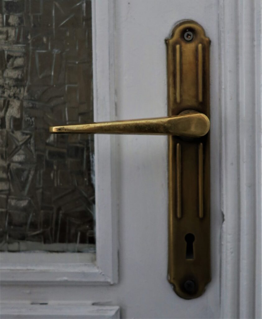 Klamka w drzwiach do mieszkania, główna klatka schodowa. Fot. Cecylia Rotter, 2020, źródło: lapidarium detalu.