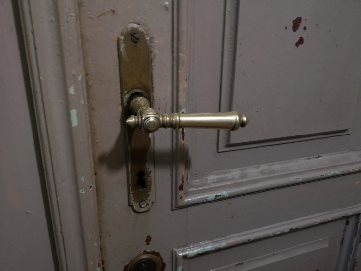 Klamka, drzwi do mieszkania, klatka schodowa w kamienicy frontowej. Fot. Anna Laskowska, 2019