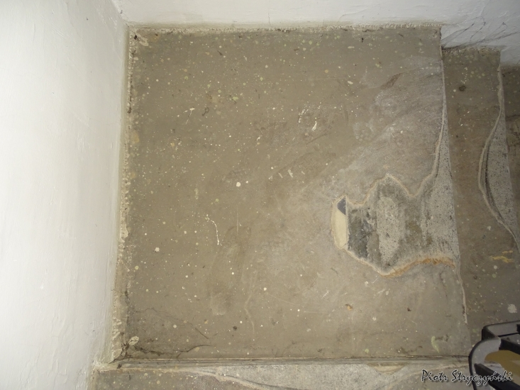 Widoczny fragment zalanej cementem okładziny ceramicznej na klatce schodowej w segmencie C. Fot. Piotr Stryczyński, 2019, źródło: zabytek.co