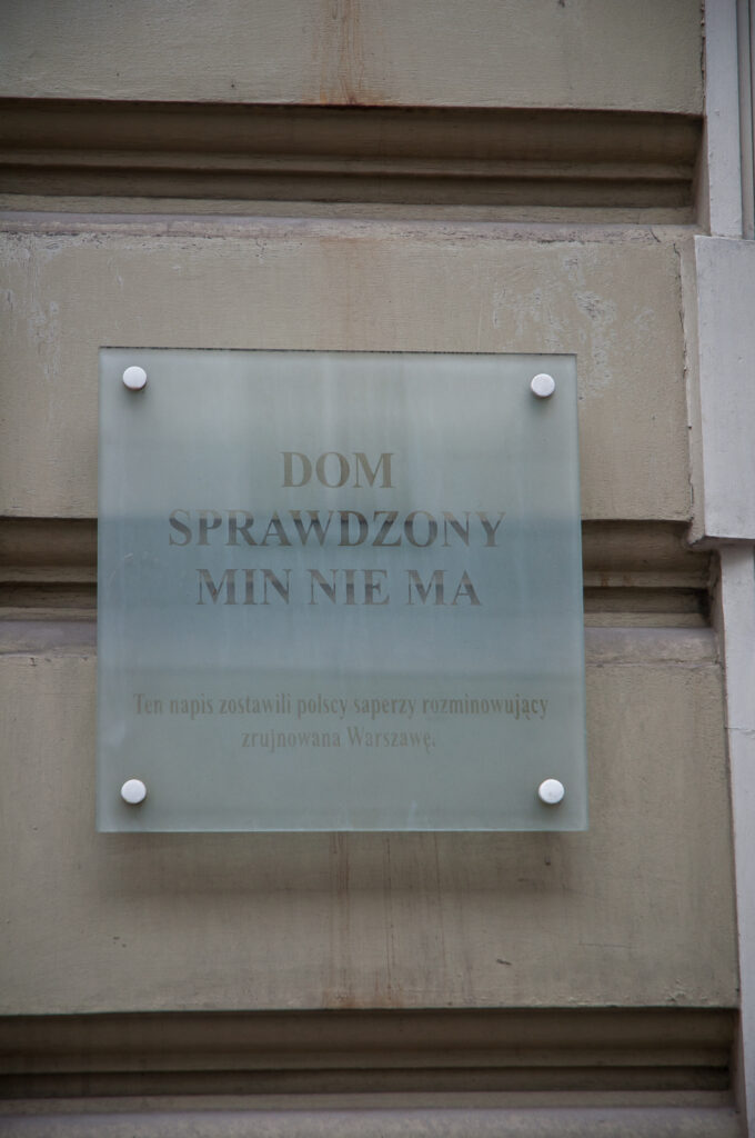 Tablica na elewacji frontowej upamiętniająca napis pozostawiony przez polskich saperów. Fot. Teresa Adamiak, 2020, źródło: lapidarium detalu.