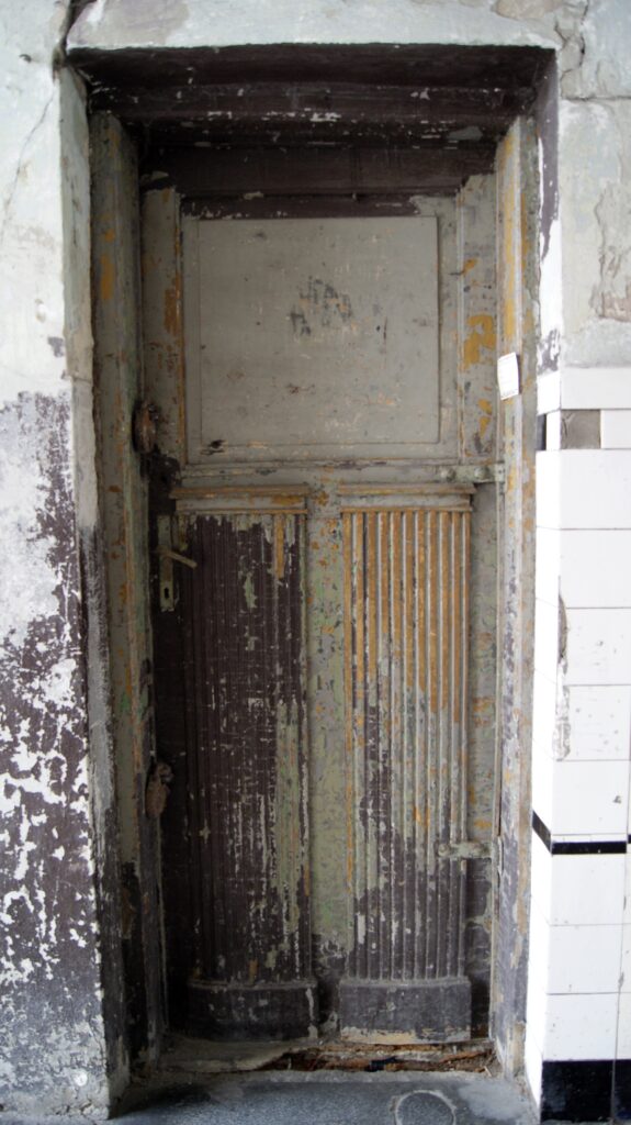 Drzwi do lokalu usługowego w przejeździe bramnym, Targowa 63. Fot. M. Wesołowska, 2021 Dokumentacja wykonana w ramach projektu „Ulica Targowa – społeczna dokumentacja zabytków”
