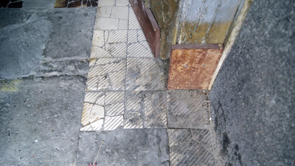 Fragment trotuaru przy wejściu do kamienicy od Targowej, Targowa 84. Fot. M. Wesołowska, 2021 Dokumentacja wykonana w ramach projektu „Ulica Targowa – społeczna dokumentacja zabytków”